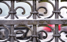 Close Up And Detail Shot Of An Old Wrought Iron Gate With Spirals, With Snow In Winter And When It Snows