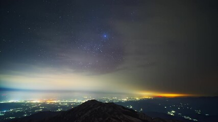 Wall Mural - Time-lapse of the starry sky at night, beautiful milky way and galaxy over the city, copy space