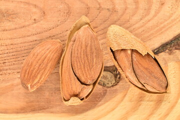 Unpeeled organic dried almonds, close-up, on a wooden table.