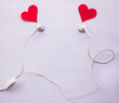 concept love music lovers earphones with red hearts coming out flat lay on white background
