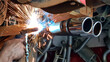  Mechanic or welder is fixing a car exhaust system by welding the exhaust pipe