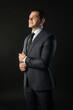 © Ilya - Young male three piece suit business man, suit standing. Happiness trendy, cool background black bodybuilder