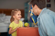 © luckybusiness - A little girl at home enjoying her father performance with a doll. Family, home, playing
