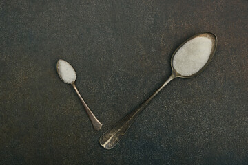 Wall Mural - Two spoons of sugar and salt on table