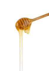 Wall Mural - Close up honey flowing from wooden dipper on white