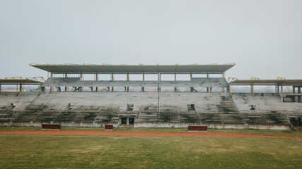 Wall Mural - Green stadium with seats in the clear sky background