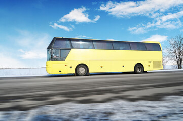 Sticker - Big yellow bus driving fast on a winter countryside road against a sky with clouds