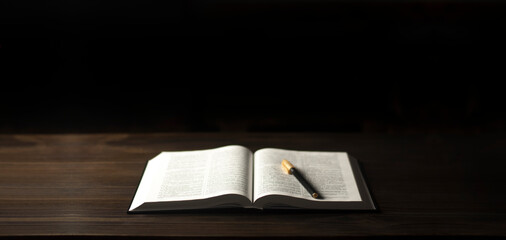 Wall Mural - Open Bible book on a wooden table. A pen. The concept of love for God's Word.