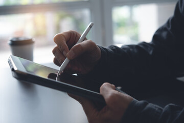 Wall Mural - E-signing, electronic signature, man hand with stylus pen signing on digital tablet, close up