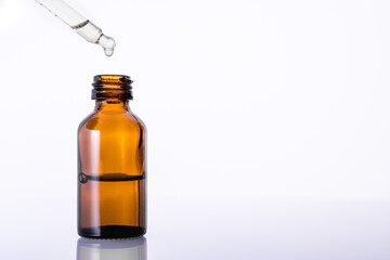  Essential oil for aromatherapy. Brown glass bottle with medicine dropper or pipette. White background. Copy space.