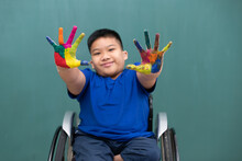 A Disabled Boy On Wheelchair Showing Hands With Colorful Colors And Smile Face