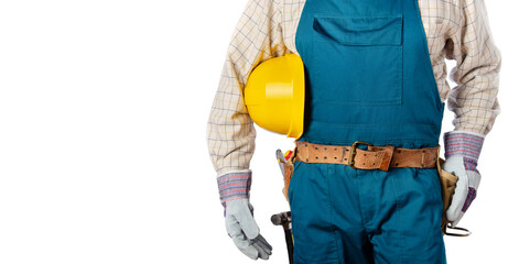 Middle aged contractor in overalls with tool belt holds yellow hard hat in his hands on white background