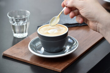 Detail of hand, glass and freshly roasted coffee.