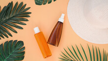 Sun Cream, Sun Hat, Lotion Bottle On Soft Orange Background. Sun Protection. Summer Time And Holiday