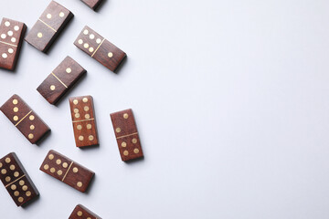 Sticker - Wooden domino tiles on white background, flat lay. Space for text