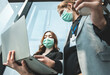 © anon - .infection of the virus coronavirus.businessman entrepreneur wears face mask standing and holding laptop with confident, with colleague in background in meeting room.