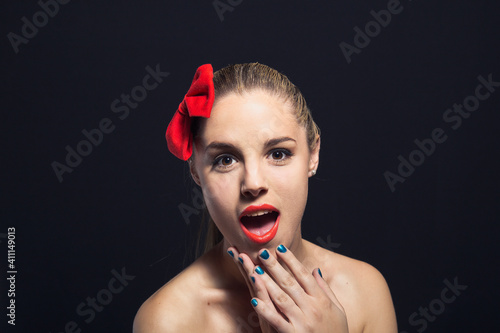 Portrait Of Surprised Shirtless Young Woman Against Black Background