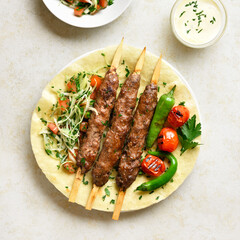 Adana Kebab with fresh vegetables on flatbread