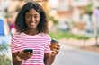 © Krakenimages.com - Young african american girl using smartphone drinking take away coffee at the city.