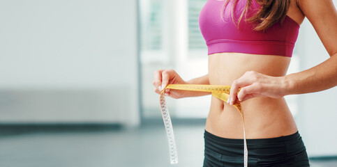 Slim woman measuring her thin waist