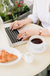 © ShevarevAlex - Hands of a woman with coffee and laptop in a summer outdoor cafe