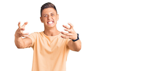 Wall Mural - Young handsome man wearing casual clothes shouting frustrated with rage, hands trying to strangle, yelling mad
