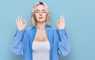 Sticker - Young blonde girl wearing casual clothes relax and smiling with eyes closed doing meditation gesture with fingers. yoga concept.