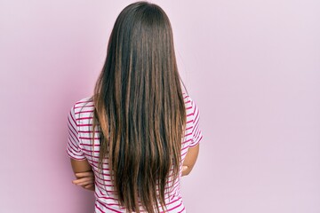 Poster - Young brunette woman wearing casual clothes over pink background standing backwards looking away with crossed arms