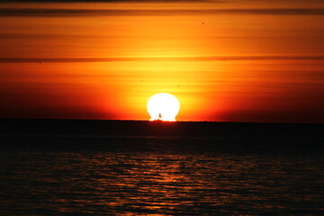 Schiff direkt vor Sonne bei Sonnenuntergang