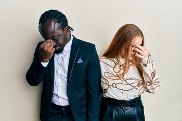 Poster - Young interracial couple wearing business and elegant clothes tired rubbing nose and eyes feeling fatigue and headache. stress and frustration concept.