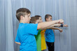 © andreyfire - Boys athletes in multi-colored T-shirts perform a hand punch on a light background