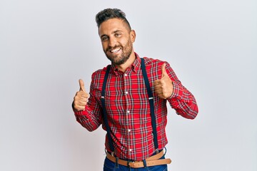 Wall Mural - Handsome man with beard wearing hipster elegant look success sign doing positive gesture with hand, thumbs up smiling and happy. cheerful expression and winner gesture.