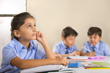 school girl thinking about something while studying in class	