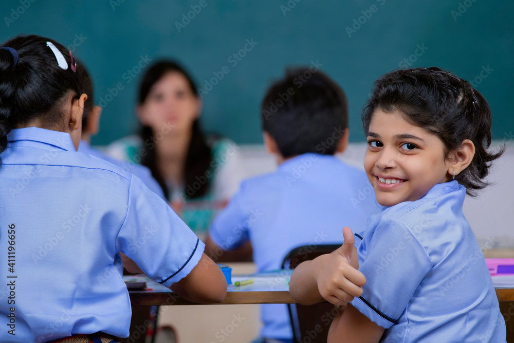 school girl smiling while teacher is sitting in class Stock Photo ...