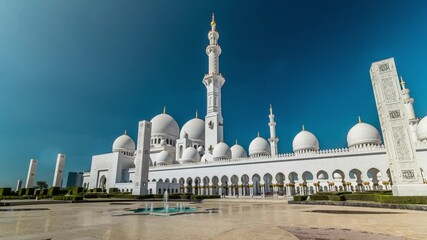 Wall Mural - Domes and fountain of Sheikh Zayed Grand Mosque timelapse hyperlapse located in Abu Dhabi - capital city of United Arab Emirates. It is largest mosque in UAE. Blue cloudy sky