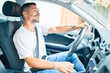 © Krakenimages.com - Young hispanic man smiling happy driving car.