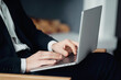 © muse studio - men's hands manager works on a laptop computer, prints a text message to a partner. A man is sitting in a chair in a modern office. administrator in a finance company