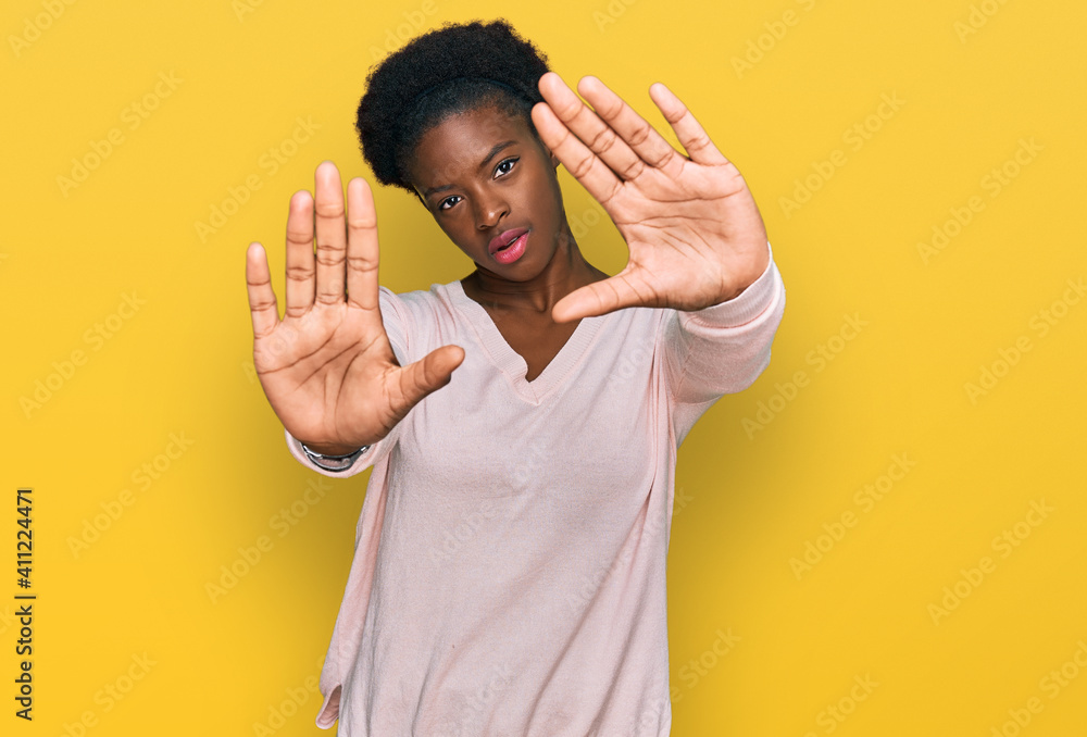 Young african american girl wearing casual clothes doing frame using hands palms and fingers, camera perspective