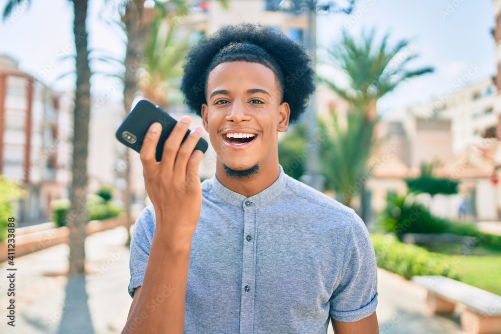 Young african american man smiling happy sending audio message using smartphone at the city.