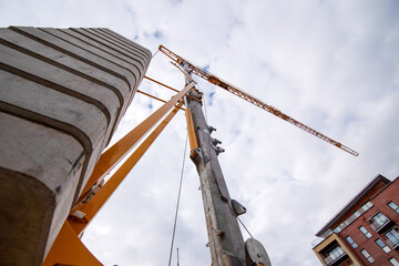 Wall Mural - Bottom view of Tower crane against cloudy sky