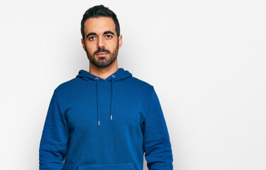 Poster - Young hispanic man wearing casual clothes with serious expression on face. simple and natural looking at the camera.