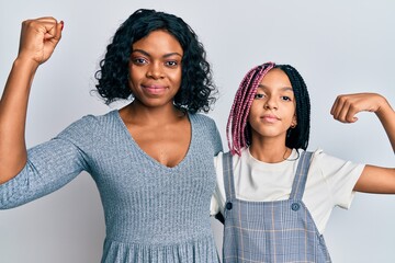 Sticker - Beautiful african american mother and daughter wearing casual clothes and hugging strong person showing arm muscle, confident and proud of power