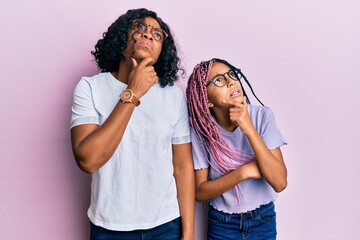 Sticker - Beautiful african american mother and daughter wearing casual clothes and glasses thinking worried about a question, concerned and nervous with hand on chin