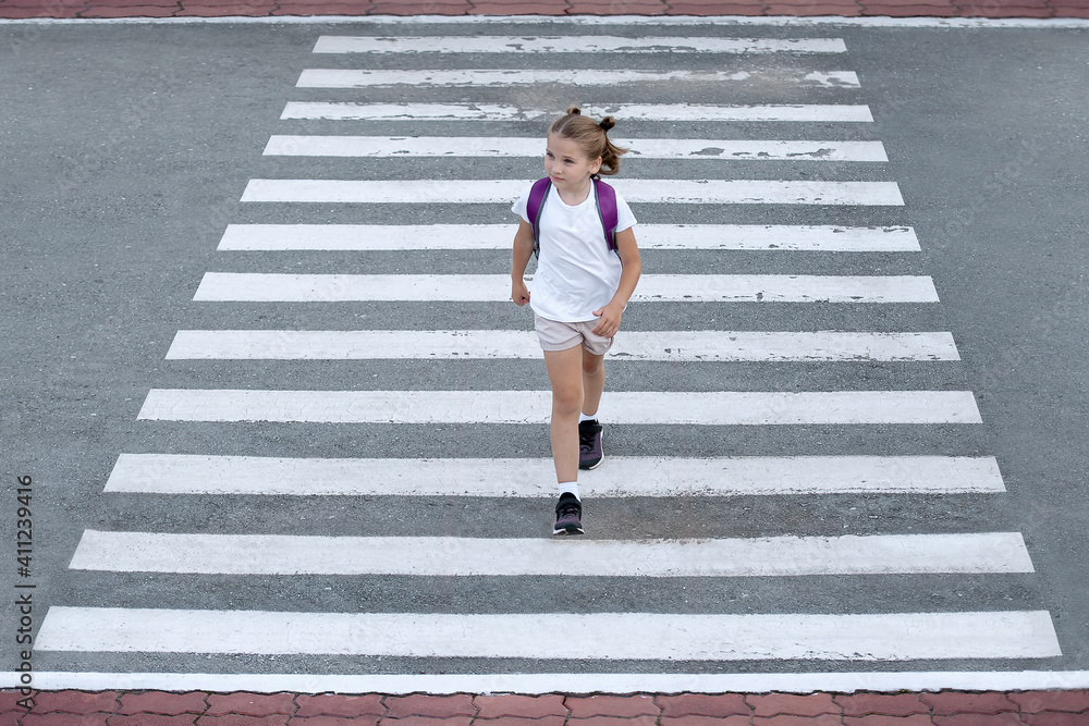 Photo Stock Schoolgirl crossing road on way to school. Zebra traffic ...