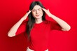 © Krakenimages.com - Young beautiful caucasian girl wearing casual red shirt with hand on head, headache because stress. suffering migraine.