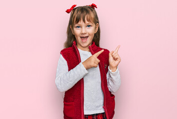 Wall Mural - Little caucasian girl kid wearing casual clothes smiling and looking at the camera pointing with two hands and fingers to the side.