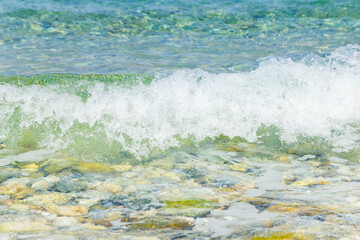 Sea wave and pebble. Summer vacation concept. Sea wave with foam incident on the coastal shingle. Travel concept