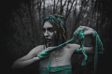 dead girl in autumn foliage wearing green and yellow robes