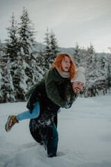 Canvas Print - Beautiful view of the girl on the shoulders of her boyfriend having fun in the snow park