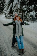 Canvas Print - Beautiful view of a couple wearing warm clothes having fun at the snow park